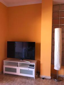 sala de estar con TV de pantalla plana en la pared en Ático Sun&Beach, en Gran Tarajal