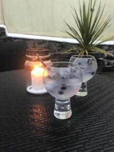two glasses and a candle on a table at Ridge Cottage Portrush in Portrush +22 photos