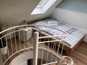 Zimmer mit einem Bett und einer Wendeltreppe in der Unterkunft Sellin Ferienwohnung Maritim in Seedorf