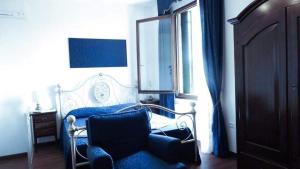 1 dormitorio con 1 cama, 1 silla y 1 ventana en B&B La Terrazza Dei Miracoli, en Venecia