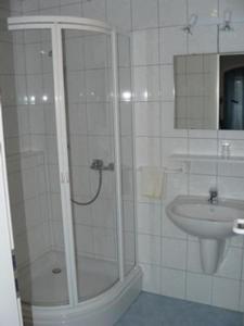 ein Bad mit einer Dusche und einem Waschbecken in der Unterkunft Hotel zur Post Garni in Landkern