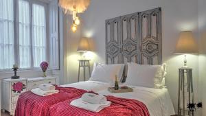 a bedroom with a large bed with towels on it at República Guest House in Coimbra