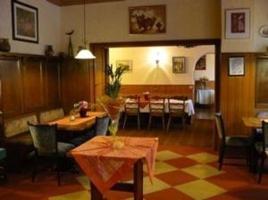 a restaurant with tables and chairs and a dining room at Hotel zur Post Garni in Landkern