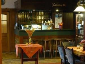a restaurant with a table and chairs and a bar at Hotel zur Post Garni in Landkern