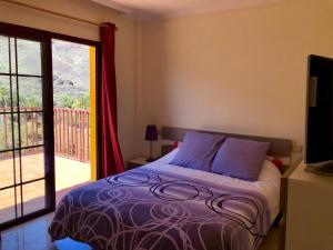 a bedroom with a bed and a sliding glass door at Apartamento Las Tejas Mogán in Mogán
