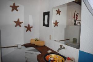 a bathroom with a sink and a toilet and stars on the wall at Posada Mexico in Zipolite