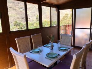 a table with chairs and plates and glasses on it at Apartamento Las Tejas Mogán in Mogán