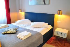 ein Schlafzimmer mit einem Bett mit Handtüchern darauf in der Unterkunft Ronis Apartments in Sibiu