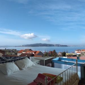 a bedroom with a bed and a view of the water at Cambados Apartamento VUT-PO-TU986D in Cambados