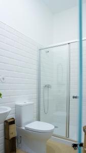 a bathroom with a toilet and a glass shower at República Guest House in Coimbra