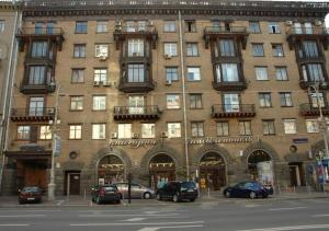 een groot bakstenen gebouw met auto's geparkeerd voor het bij Apartment Arena City Loft in Kiev