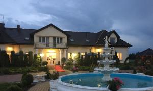 a large house with a fountain in front of it at Motel Jaśminowy Dworek Człekówka 67 B in Człekowka +3 photos