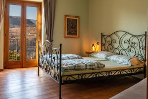 Schlafzimmer mit einem Bett mit einem schmiedeeisernen Rahmen in der Unterkunft Casa San Francesco in Tremosine sul Garda