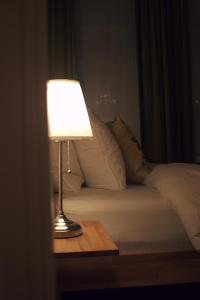 una lámpara sentada en una mesa junto a una cama en Quiet apartment in Antwerp near parc - B&B InterMezzo - business & leisure, en Amberes