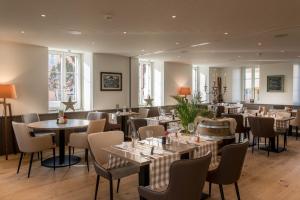 a restaurant with tables and chairs in a room at L’Auberge de Mézières in Mézières