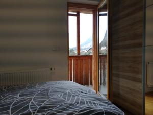 een slaapkamer met een bed en een groot raam bij Apartma Lucijana in Mojstrana