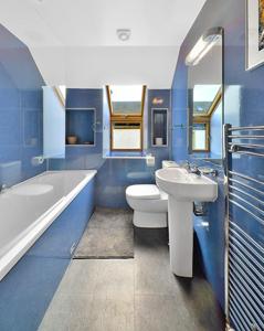 een badkamer met een wastafel, een toilet en een bad bij The Arches, Borthwick Mains Farm, in Gorebridge