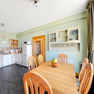 een keuken met een houten tafel en stoelen in een kamer bij The Arches, Borthwick Mains Farm, in Gorebridge