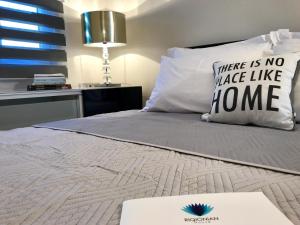 a bed with a pillow that says there is no place like home at RIQIONIAN House in Vromonérion