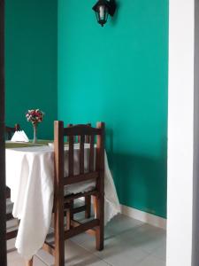 una mesa con una silla y una pared verde en Vero!! en General Rodríguez