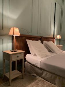 ブザンソンにあるL'Annexe Apparthôtel du 11 D, 4 étoilesのベッドルーム1室(ベッド1台、ランプ付きテーブル付)