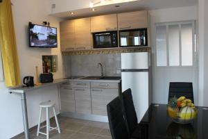 a small kitchen with a sink and a microwave at LES MULTIPLIANTS in Le Moule