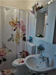 モーディカにあるLa Casa di Pinaのバスルーム(シンク、花のシャワーカーテン付)