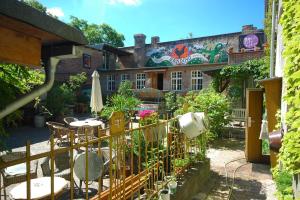 un patio extérieur avec des tables et des chaises et un bâtiment dans l'établissement Sandino Hostel - Solo Traveler Sanctuary, à Berlin