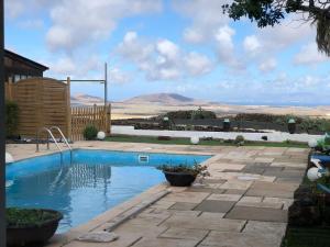 a swimming pool in a yard with mountains in the background at Loft Armony in Villaverde