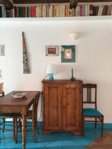 una sala da pranzo con tavolo, sedie e armadio di Appartamento chic Marciana Marina (Isola d’Elba) a Marciana Marina