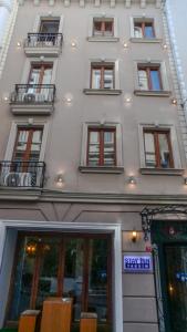 a tall white building with chairs in front of it at Stay Inn Taksim Hostel in Istanbul