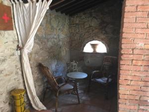 Habitación con sillas, mesa y ventana en Agriturismo le Colline, en Montescudaio