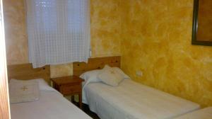 a bedroom with two beds and a window at Casas Azahar-Alucema in Zahara de la Sierra