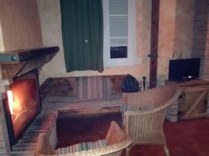 a living room with a fireplace and a television at Casas Azahar-Alucema in Zahara de la Sierra