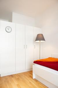 ミュンヘンにあるMyRoom - Top Munich Serviced Apartmentsの白いベッドルーム(ベッド1台、ランプ付)