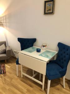 a desk with a blue chair and a table with a blue chair at Flair and Design Apartment! in Vienna