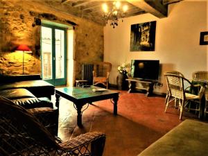 a living room with a table and a tv at Casa Rural Cabo la Aldea in Mogarraz