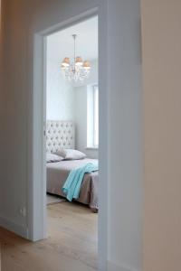 een slaapkamer met een bed en een kroonluchter bij ZEN op Vakantie - Zen aan Zee Duinbergen in Knokke-Heist