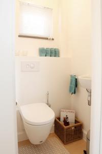 een witte badkamer met een toilet en een wastafel bij ZEN op Vakantie - Zen aan Zee Duinbergen in Knokke-Heist