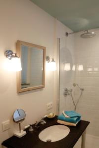 a bathroom with a sink and a shower with a mirror at ZEN op Vakantie - Zen aan Zee Duinbergen in Knokke-Heist