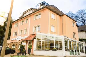 ein großes rosafarbenes Gebäude mit vielen Fenstern in der Unterkunft Langerfelder Hof in Wuppertal