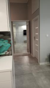 a mirror in a room with a hallway at Apartament 4 przy Parku Leśnym in Polanica-Zdrój