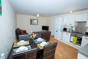 a kitchen and living room with a table and chairs at The LightHouse in Coventry