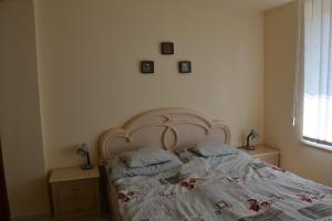 a bedroom with a bed with two pillows on it at Arany Tisza Apartmanház in Poroszló