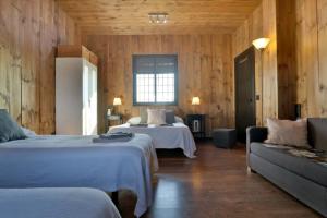 Fuente Palmera的住宿－Casa Rural Ecuestre，酒店客房,设有两张床和一张沙发