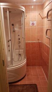 a bathroom with a shower and a tiled floor at Adart Apartment in Narva