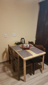 a wooden table with chairs and a tea pot on it at Adart Apartment in Narva +4 photos