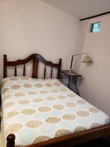 a bed in a bedroom with a white wall at Departamento Godoy Cruz in Godoy Cruz