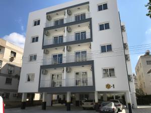 a white building with cars parked in front of it at Cozy Flat in the heart of North Nicosia --- 55-1 in North Nicosia
