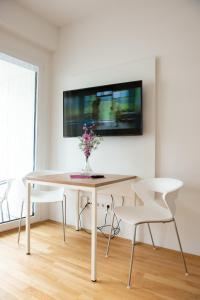 a white dining room with a table and two white chairs at MyRoom - Top Munich Serviced Apartments in Munich